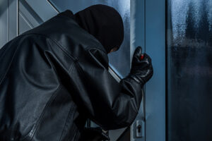 burgler with screwdriver at front door